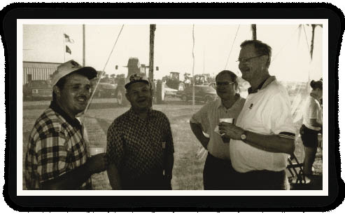 Allen Rider, vice president of New Holland North American Agriculture (rt), shares a coffee with some new combine owners during a New Holland dealer open house (circa 2000). He says his best dealers learned that the first step in selling a new combine was to have a customer waiting to buy the ones they were trading in.