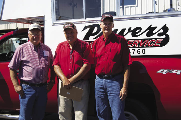 Johnson Tractor partners Leo (rt) and Eric (ctr) Johnson ran their most recent auction with the help of Powers Auction Service and auctioneer Dan Powers (left). 